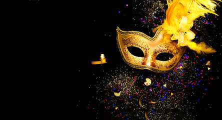 Masquerade mask on black background with sparkles. The concept of traditional holidays. Copy space - obrazy, fototapety, plakaty