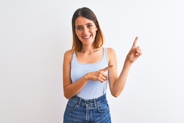 Beautiful redhead woman standing over isolated background smiling and looking at the camera pointing with two hands and fingers to the side.