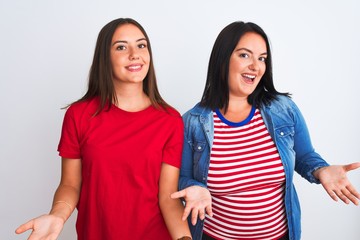 Young beautiful women wearing casual clothes standing over isolated white background smiling cheerful with open arms as friendly welcome, positive and confident greetings