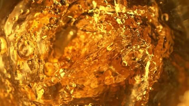 Super slow motion of pouring whiskey, rum or ice tea, inside bottle view. Filmed on high speed cinema camera, 1000 fps.