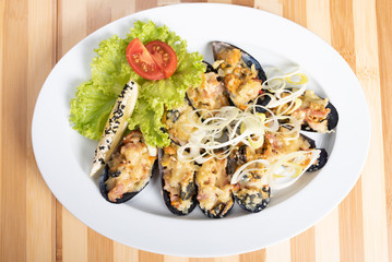 Baked mussels in half shell with filling and side dish.