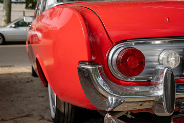 Obraz na płótnie Canvas Detail of rear light of a red vintage retro automobile (shallow depth of field)