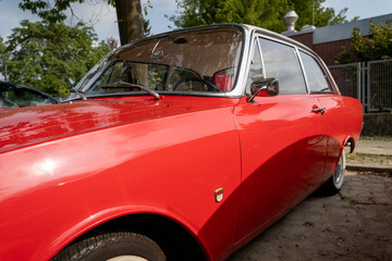 Fototapeta na wymiar Detail side view of a red vintage retro automobile (shallow depth of field)