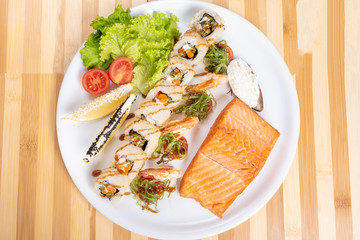Assorted sushi, shrimp, and a piece of grilled salmon.