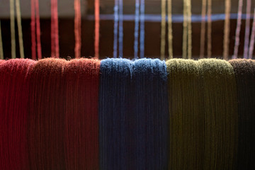 colored woolen threads on an old loom, Traditional Yarn in Canada.