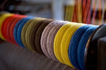 colored woolen threads on an old loom, Traditional Yarn in Canada.