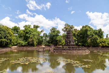 Fototapeta na wymiar Neak Pean temple in rainy season. The trees are green, the sky is blue some white clouds. Perfect conditions and a perfect travel opportunity.