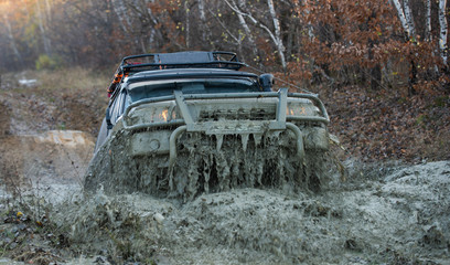 4x4 travel trekking. Track on mud. Off-road vehicle goes on the mountain. Mud and water splash in off road racing. Safari. Offroad. Adventure travel. Off-road travel on mountain road. Offroad vehicle © Volodymyr