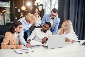 Mixed races corporate young coworkers which discussing business strategy of their successful...