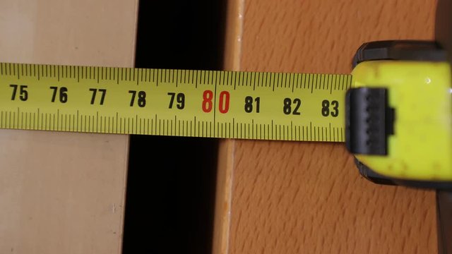 Using measuring tape to check dimensons of furniture