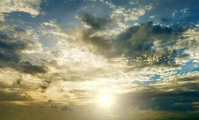 Sunset with sun rays, sky with clouds and sun.