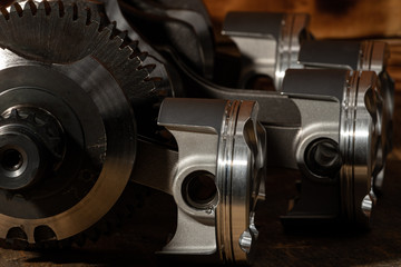 high performance motorcycle engine parts on a workbench. pistons connecting rods clutch and tools 