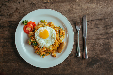 Pad Thai noodles with Omelette and tomato on wooden table