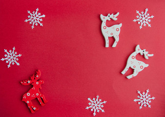 White snowflakes and deer on a red background. Postcard for Christmas and New Year, Place for text.