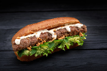 close up of kebab sandwich on black wooden background