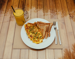 Omelet with vegetables, bread toast and fresh Juice on white a plate