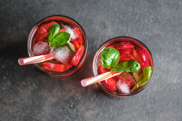 Homemade strawberry lemonade with basil on a dark background top view.