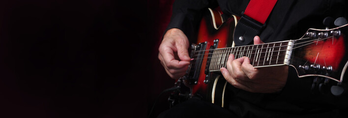 Guitarist hands and guitar on a black background close up. playing electric guitar. copy spaces. 