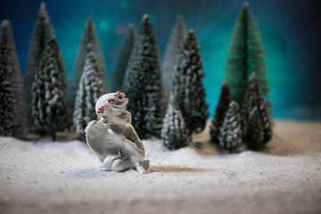 Obraz premium Little white guardian angel in snow. Festive background. Christmas decorations.