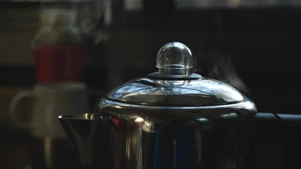 A pot of coffee purcolating on the stove