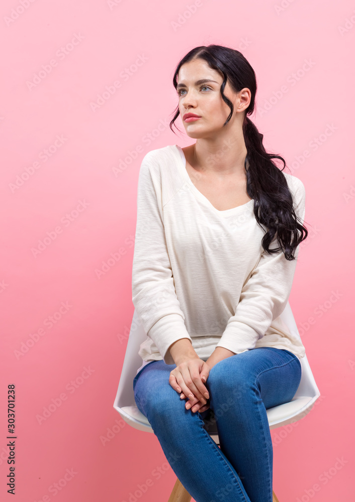 Wall mural portrait of a young woman on a pink background