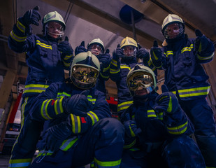 Portrait of group of firefighters wearing protective uniform inside the fire station