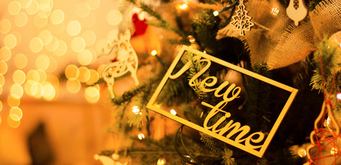 New Year's decoration on the Christmas tree with beautiful luminous yellow blurs with copy space for a text