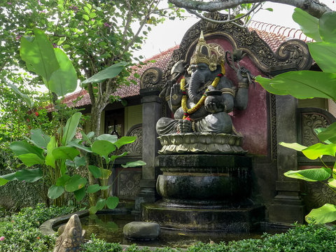 a statue of ganesh fountain in a garden at ubud on the island of bali