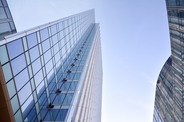 Obraz na płótnie Canvas Modern office building wall made of steel and glass with blue sky