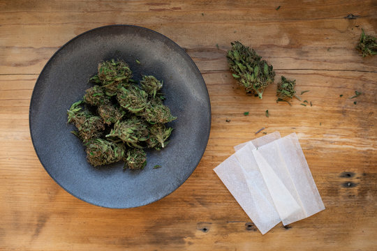 Still life of marijuana in bowl with rolling papers