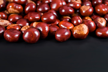 Background of chestnuts on a black table. Selective focus.