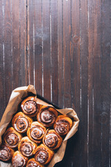 Cinnamon rolls with sugar icing  ready to be eaten for christmas holiday, top view over a rustic...