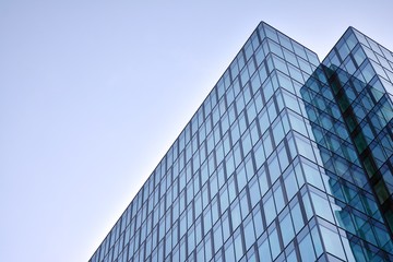 Modern office building wall made of steel and glass with blue sky