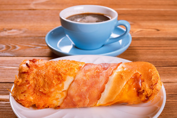 side view bread with bacon and shredded pork and cup of coffee on back horizontal composition
