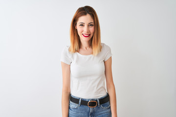 Beautiful redhead woman wearing casual t-shirt standing over isolated white background looking away to side with smile on face, natural expression. Laughing confident.