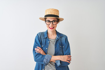 Redhead woman wearing denim shirt glasses and hat over isolated white background happy face smiling with crossed arms looking at the camera. Positive person.