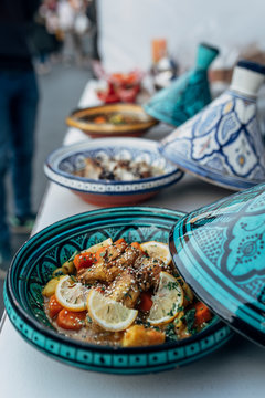 A close up picture of an african tagine chicken served in traditional maghreb food bowls
