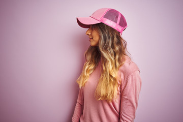 Young beautiful woman wearing cap over pink isolated background looking to side, relax profile pose with natural face with confident smile.