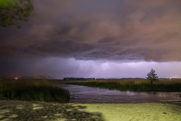 the lightning strikes the water on the river at night