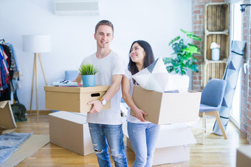 Young beautiful couple moving cardboard boxes at new home