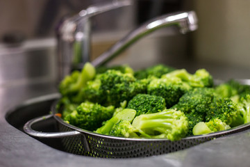 fresh broccoli washed in the sink,