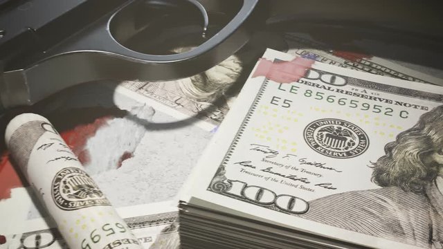Few ammo bullets on a table in the dark covered with countless dollar bills.4KHD