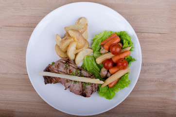 grilled meat accompanied by salad and potato