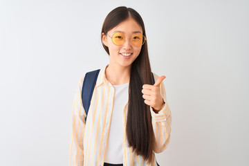 Young chinese student woman wearing glasses and backpack over isolated white background doing happy...