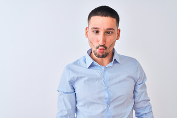 Fototapeta premium Young handsome business man standing over isolated background making fish face with lips, crazy and comical gesture. Funny expression.
