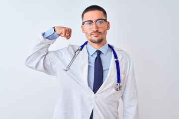 Young doctor man wearing stethoscope over isolated background Strong person showing arm muscle, confident and proud of power