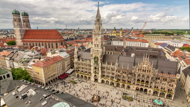 Panoramic view of Marienplatz. Munich city skyline. Clouds move fast across the blue sky. Time lapse video.