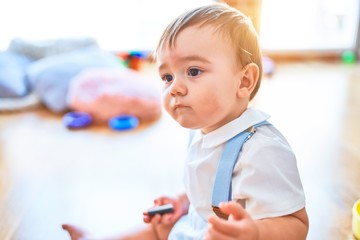 Adorable toddler playing around lots of toys at kindergarten