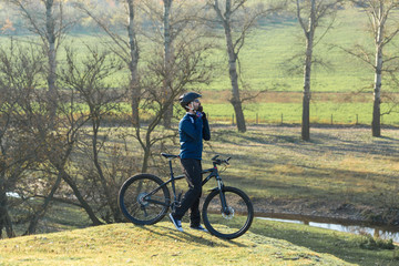 Fototapeta premium Cyclist in pants and fleece jacket on a modern carbon hardtail bike with an air suspension fork rides off-road. 