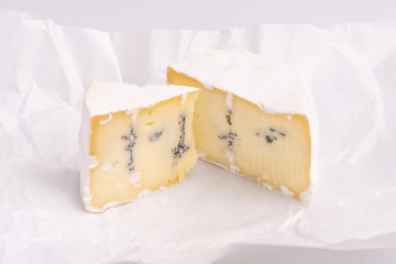 Blue cheese with white surface, isolated on white background, soft light, studio photo. Mix of...